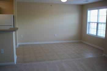 A room with a window and a carpeted floor